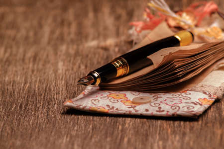 Designer notebook and ink pen on a wooden backgroundの写真素材