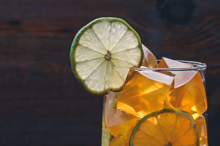 cocktail with yellow cubes of ice and lemon / cocktail with transparent cubes of ice and a lemonの写真素材
