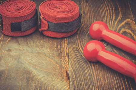 sports accessories for boxing / dumbbells and bandage on a wooden tableの写真素材