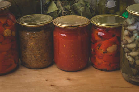 Jars of vegetable on a wooden tableの写真素材