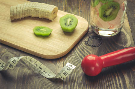 fitness background from smoothie, banana, kiwi, centimeter and dumbbell / fitness concept with smoothie, banana, kiwi, centimeter and dumbbellの写真素材