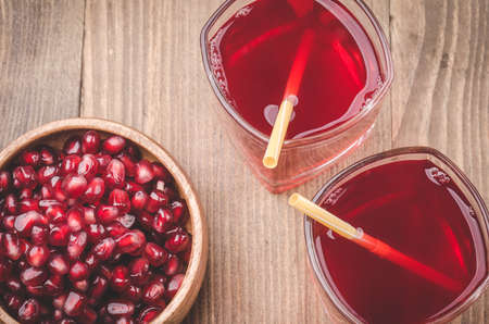 garnet juice in glasses top view / garnet juice in glasses on a wooden backgroundの写真素材