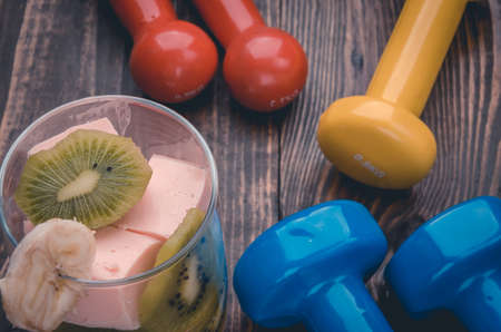 abundance of dumbbells and smoothie top view / sports equipment and smoothie on a wooden backgroundの写真素材