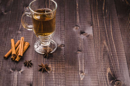 Glass with mulled wine / glass of wine with spices on a wooden backgroundの写真素材