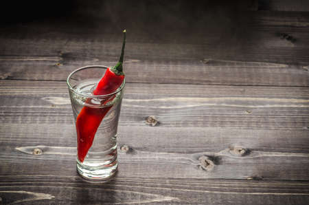 Alcohol with pepper on a wooden tableの写真素材