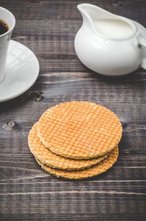 Breakfast with wafers, coffee and cream / wafers, coffee and cream on a wooden table