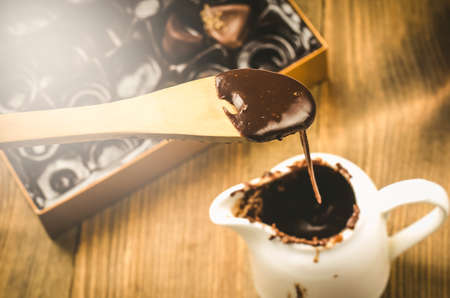 Chocolates and liquid chocolate in a cup and candies. Top viewの写真素材