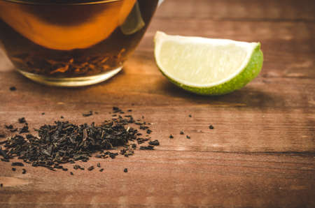 tea on a wooden table with a limeの写真素材