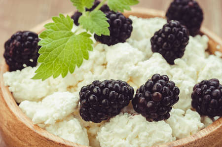 cottage cheese with in a wooden bowlcottage cheese with in a wooden bowl. Close upの写真素材