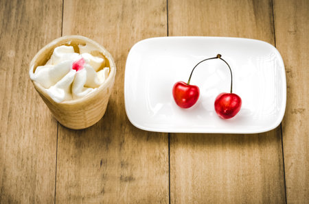 ice cream in a glass with cherry in a white plateice cream in a glass with cherry in a white plate....