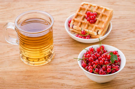 wafers with red berries and a glass of tea/wafers with red berries and a glass of tea. Selective focusの写真素材