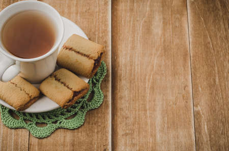 white cup of tea with cookies on a wooden background/white cup of tea with cookies on a wooden background. With copy space. Top viewの写真素材