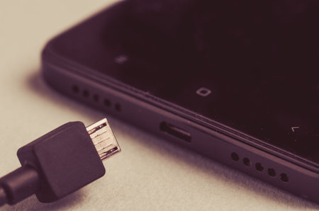 black smartphone and charger. Close up. Tonedの写真素材