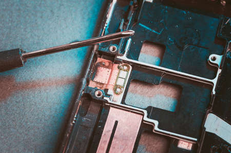 disassembled smartphone and the screw-driver. Top view. Tonedの写真素材