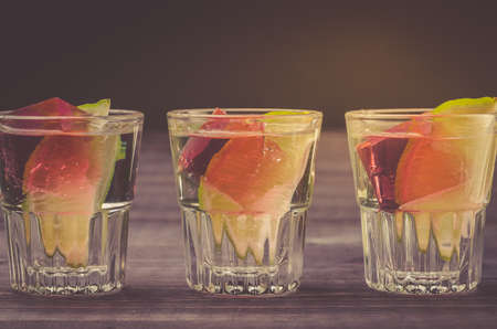 Alcohol shots with a lime on a wooden table/Alcohol shots with a lime on a wooden table. Close upの写真素材