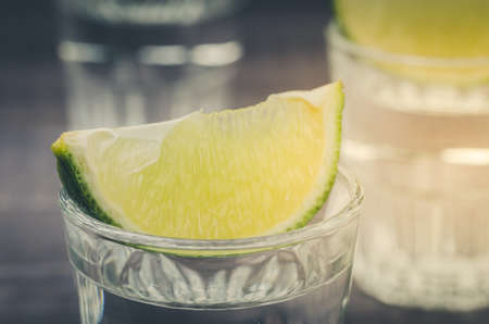 glass of tequila with a lime/glass of tequila with a lime from above. selective focusの写真素材