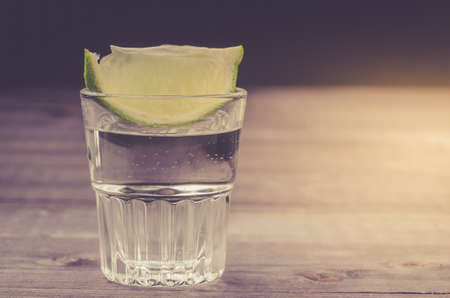 glass of tequila with a lime from above/glass of tequila with a lime from above. Close upの写真素材