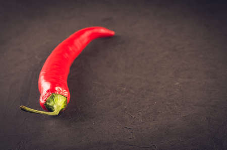 red hot Chile pepper on a dark stone/red hot Chile pepper on a dark stone background. Selective focus. Copy spaceの写真素材