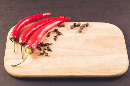 Red hot chili peppers and spices/Red hot chili peppers and spices on a empty cutting board. Copy spaceの写真素材