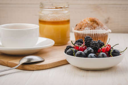 tea with fresh berries, cake and honey/healthy breakfast: tea with fresh berries, cake and honey. Selective focusの写真素材
