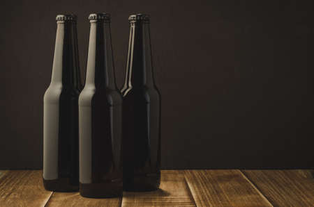 Three bottle of beer on a dark background/Three bottle of beer on a dark background, selective focus and copyspace
の写真素材