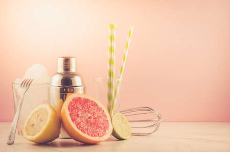 Cocktail making bar tools, shaker, tropical fruits on a pink background/Cocktail making bar tools, shaker, tropical fruits on a pink background. Selective focus and copyspace
の写真素材