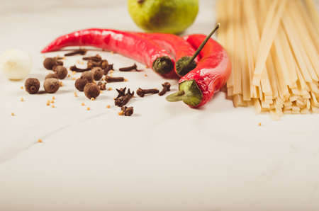 spices, chili pepper and spaghetti on a white marble background. Copy spaceの写真素材