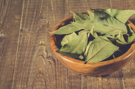 bay leaf in a wooden bowl on a wooden background. selective focusの写真素材