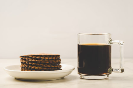Coffee glass with cookies on white background. Selective focus