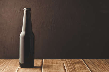 black bottle of beer on a dark background/black bottle of beer on a dark background. Copy spaceの写真素材
