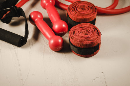 red dumbbells, bandage and jump rope/healthy concept with red dumbbells, bandage and jump rope on a...
