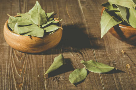 bay leaf in a two wooden bowl/spices of bay leaf in rural style on a wooden table. selective focusの写真素材