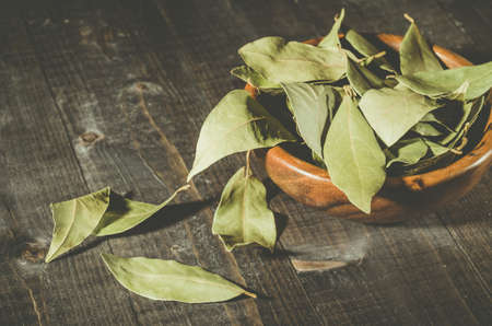 bay leaf in a wooden bowl/bay leaf on a wooden surface dark wooden background. selective focusの写真素材