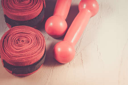 sport and boxing concept with red dumbbells and bandage/sport and boxing concept with red dumbbells and bandage on a white stoneの写真素材