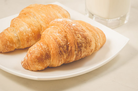 croissants in a white plate on a white table/croissants in a white square plate on a white table. Selective focusの写真素材