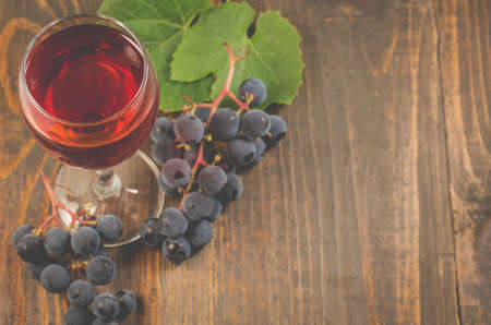 glass of wine and grape/glass of red wine and grape on a wooden background. Top view and copyspaceの写真素材