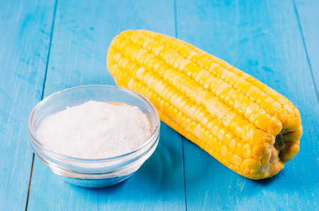 boiled appetizing corn and salt on a blue wooden background, vegetarian concept. Selective focus. Healthy food.の写真素材