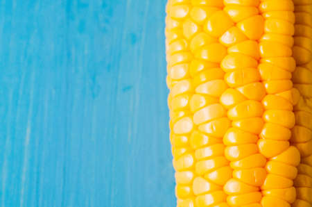 boiled corn on a blue wooden table/Vegetarian concept. Close up. Boiled corn on a blue wooden table. Copy spaceの写真素材