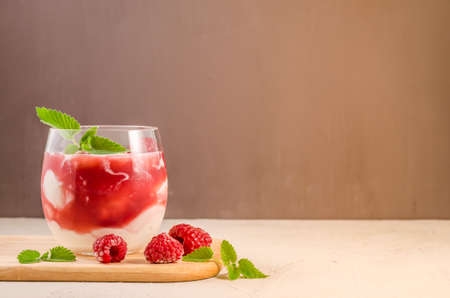 glass of raspberry yogurt with mint/yogurt with raspberry and mint closeup. Healthy breakfast. Copy spaceの写真素材