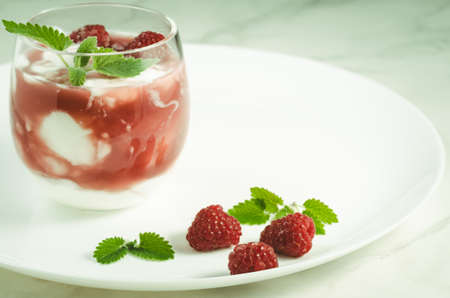 Health and diet concept/healthy breakfast: glass with yogurt or milk, fresh berries and mint over white. Selective focusの写真素材