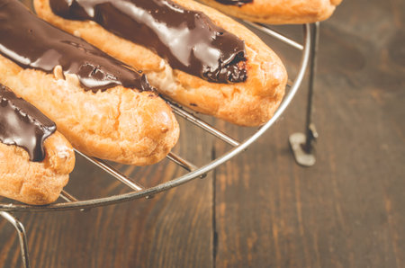 fresh eclairs on a wooden table. Selective focus