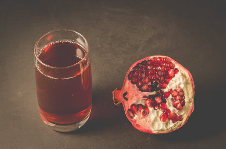 Ripe pomegranate, a piece and a glass of juice/Ripe pomegranate, a piece and a glass of juice on a...