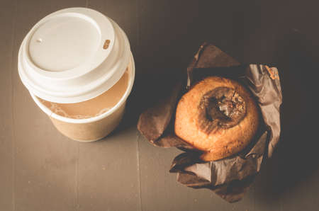 cake with a chocolate stuffing and cappuccino plastic cup/cake with a chocolate stuffing and cappuccino plastic cup on a dark background. Top viewの写真素材