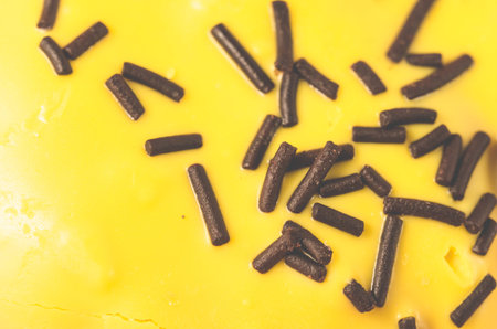 yellow glaze with dark chocolate sticks/yellow glaze decorated with dark chocolate sticks. Close up