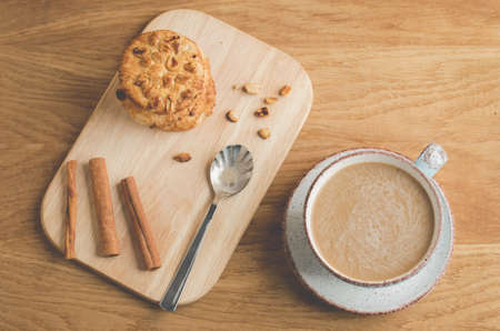 cinnamon sticks, cookies with nuts and a cup of coffee/cinnamon sticks, cookies with nuts and a cup of coffee on a wooden tray. Top viewの写真素材