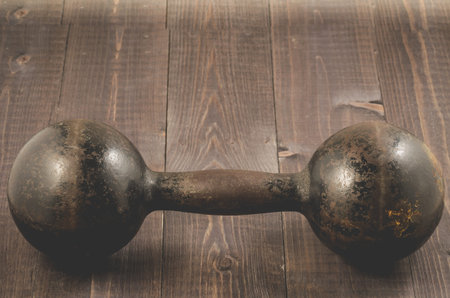 iron dumbbell in fitness gym/Dumbbell in fitness gym on a dark wooden background. Selective focus