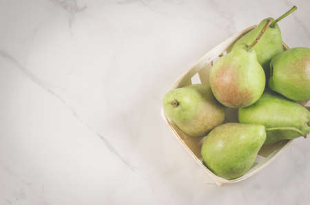 pears in a straw box on a white marble background/pears in a straw box on a white marble background, top view and copy spaceの写真素材