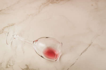 poured wine glass on marble background/poured red wine glass on marble background. Copyspaeの写真素材