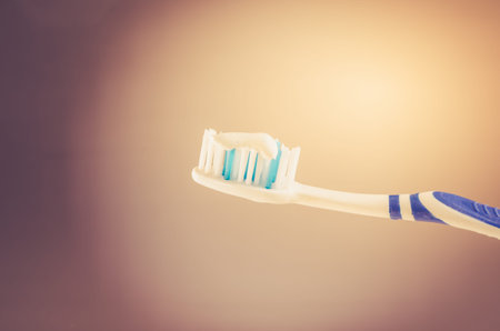 toothbrush with toothpaste on a gray background, close up