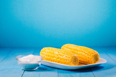 Ð¡orn with salt. Selective focus and copy space. Yellow corn in a white bowl and salt glass on...